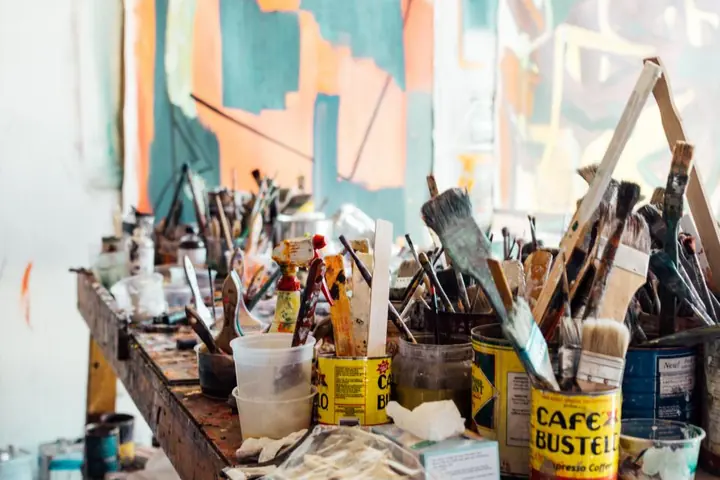 Craft table full of paint jars and brushes