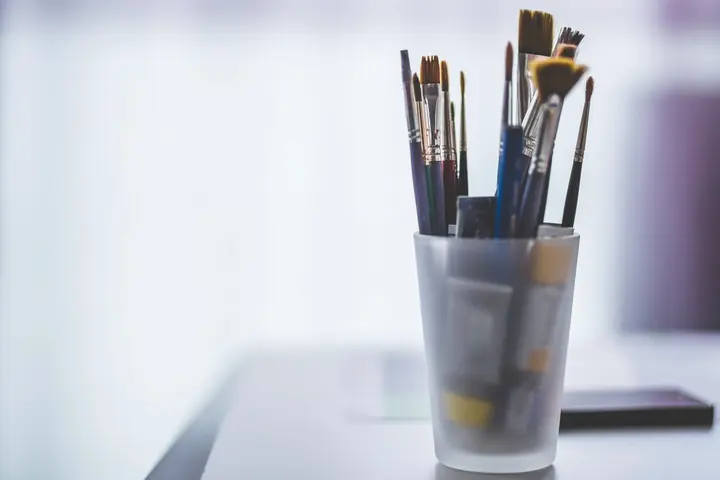 Cup of paintbrushes on a bright table