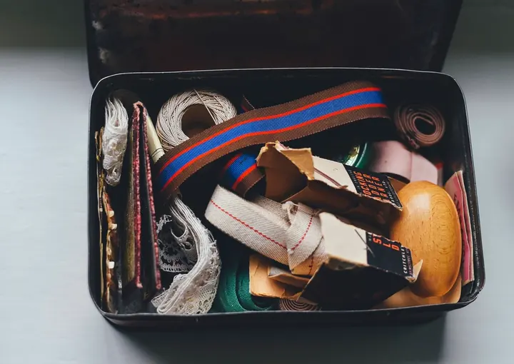 Tin box filled with ribbons, twine and craft supplies