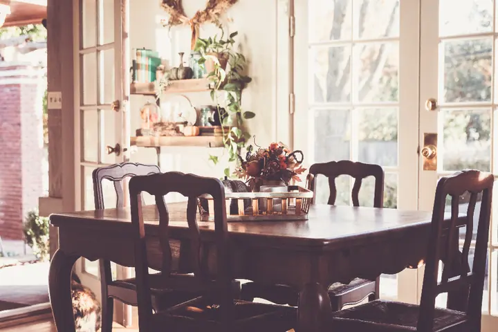 Farmhouse dining room with a distressed wood table and painted chairs