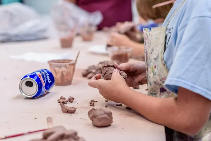 Kids shaping clay at a craft table