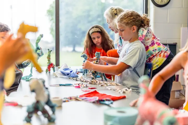 Children making crafts together at a kitchen table
