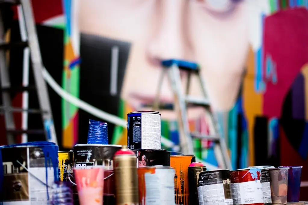 Open cans of paint in soft colors with stir sticks