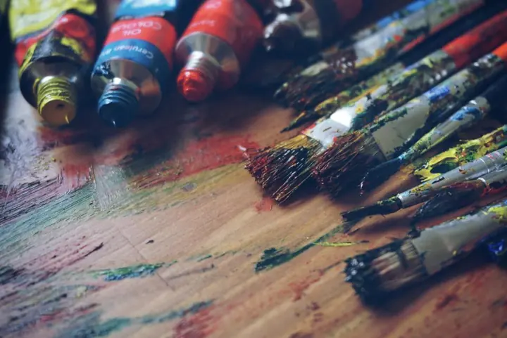 Colorful tubes and jars of paint on a craft table