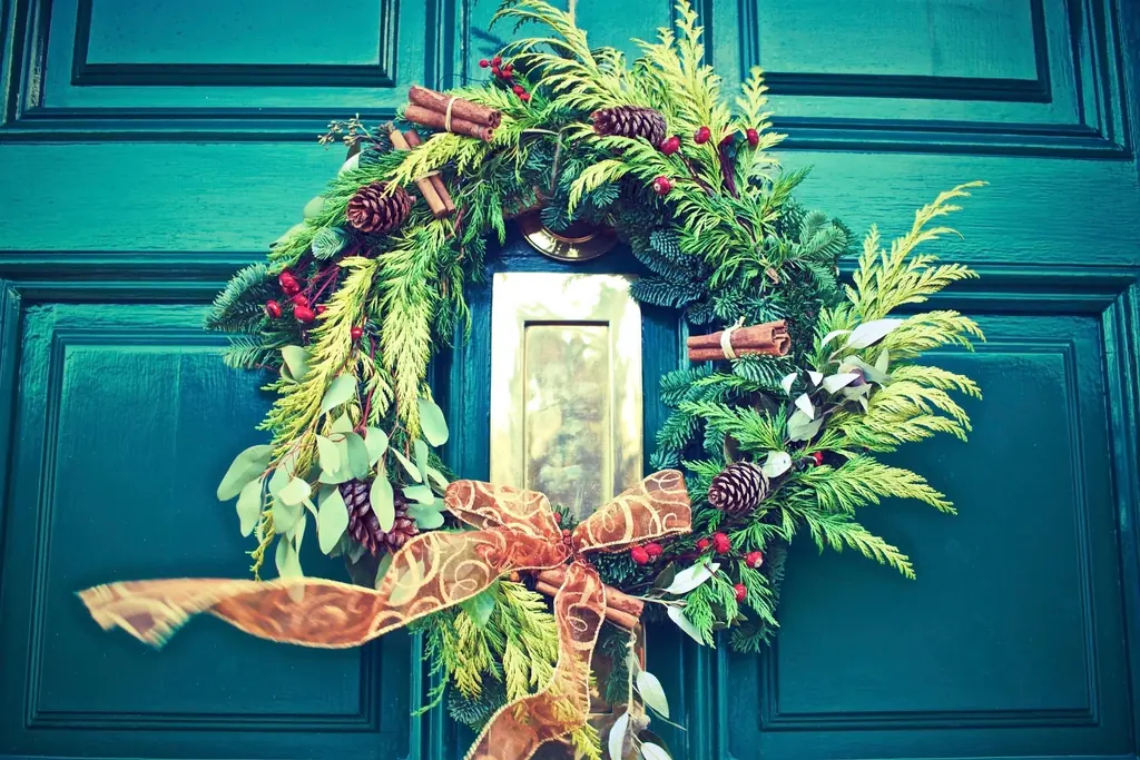 Farmhouse-style greenery wreath hanging on a front door